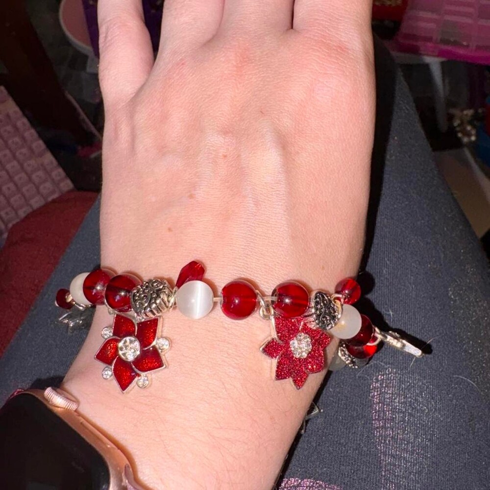 Red and white beaded bracelet with red flower charms and silver accents #beaded